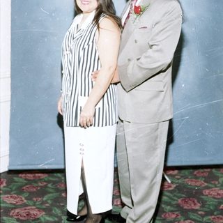 Couple posing formally in formal attire.