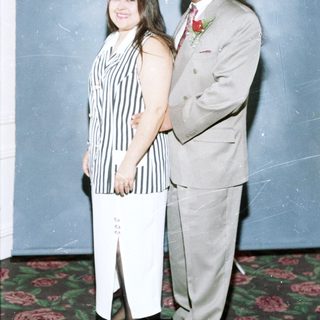 Couple posing formally in formal attire.