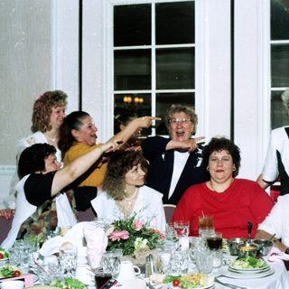 Group celebrating at a formal indoor dinner party.