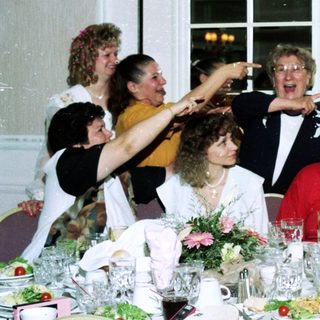 Group celebrating at a formal indoor dinner party.