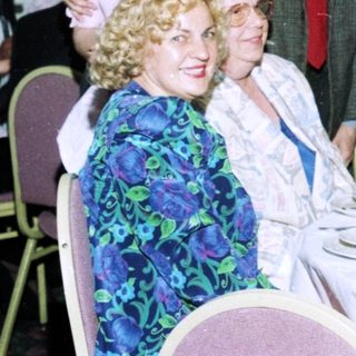 Formal dinner party with seated and standing guests.
