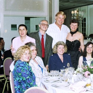 Formal dinner party with seated and standing guests.