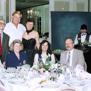 Formal dinner party with seated and standing guests.