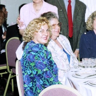 Formal dinner party with seated and standing guests.