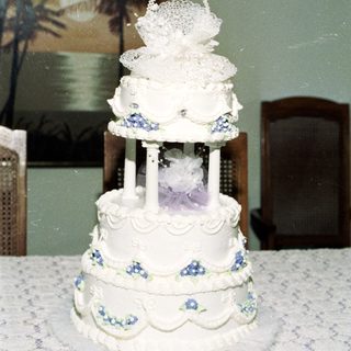 Elegant three-tiered wedding cake with floral decorations.