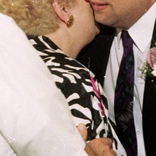 Wedding ceremony with groom kissing bride's cheek.