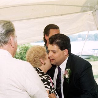 Wedding ceremony with groom kissing bride's cheek.