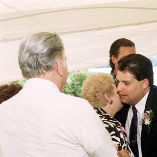 Wedding ceremony with groom kissing bride's cheek.