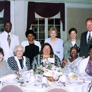 Group posing at a formal indoor banquet.