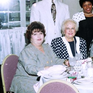 Group posing at a formal indoor banquet.