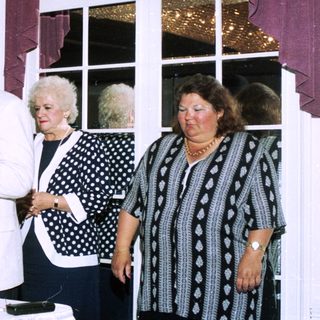 Group at indoor event, man speaking into microphone.
