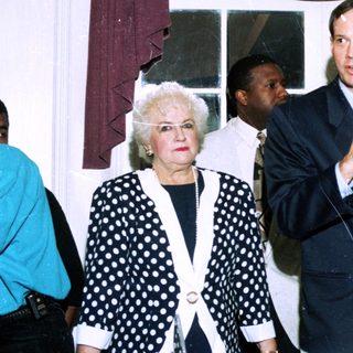 People at indoor event speaking into microphone.