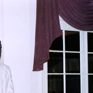Woman speaking at indoor event with microphone.
