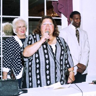 Woman speaking at indoor event with microphone.