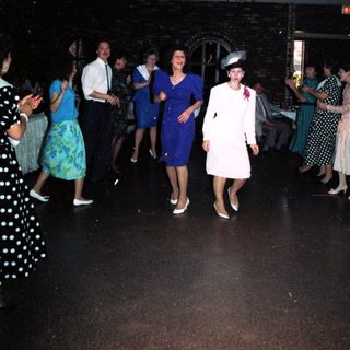 Formal dance party with 1950s-style attire.