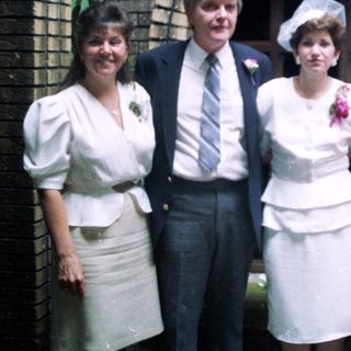 Group posing in formal attire at wedding.
