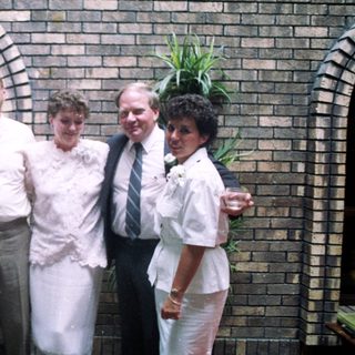 Group posing in formal attire at wedding.