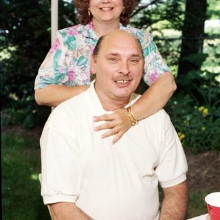 Happy couple posing outdoors under tent.