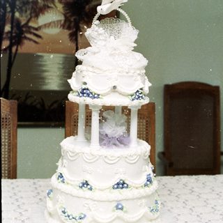 Elegant three-tiered wedding cake with floral decorations.