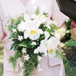 Wedding ceremony with bride, groom, officiant, and guests outdoors.