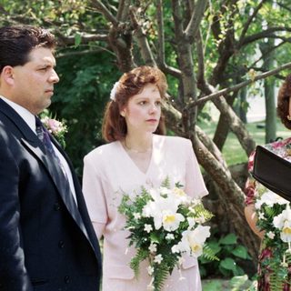Wedding ceremony with bride, groom, officiant, and witnesses.
