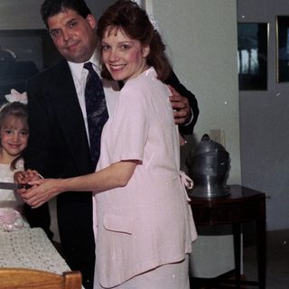 Family celebrating wedding reception with cake cutting.