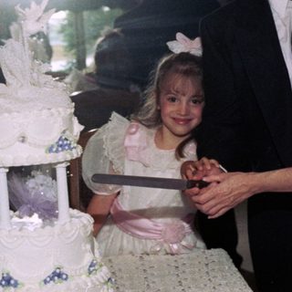 Family celebrating wedding reception with cake cutting.
