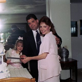 Family celebrating wedding reception with cake cutting.