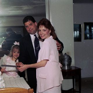 Family celebrating wedding reception with cake cutting.