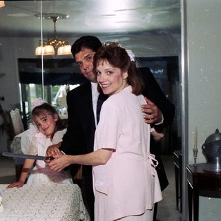 Family celebrating wedding with cake cutting.