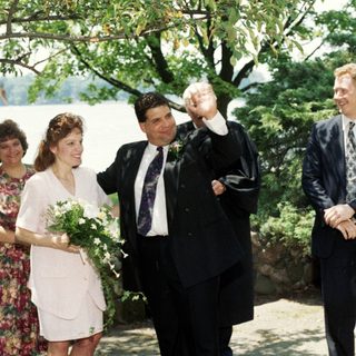 Wedding ceremony with bride, groom, and guests outdoors.