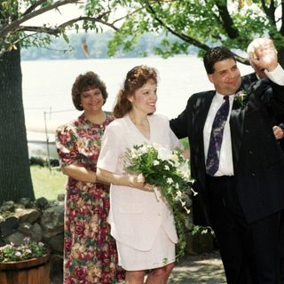Wedding ceremony with bride, groom, and guests outdoors.