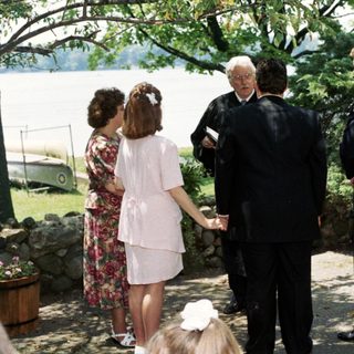 Outdoor wedding ceremony group photo near lake.