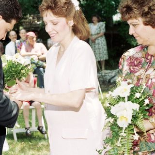 Wedding ceremony exchange of bouquets outdoors.
