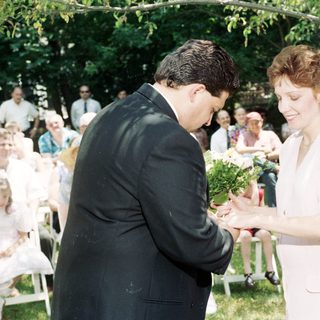 Wedding ceremony exchange of bouquets outdoors.