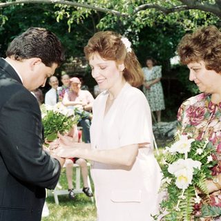 Wedding ceremony exchange of bouquets outdoors.