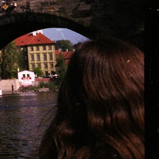 Historic stone bridge over river with statues.