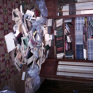 Disorganized room with scattered books and papers.
