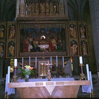 Gothic cathedral altar with religious artwork and candles.