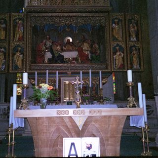 Gothic cathedral altar with religious artwork and candles.