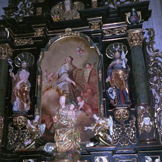 Baroque altar with ornate religious sculptures and paintings.