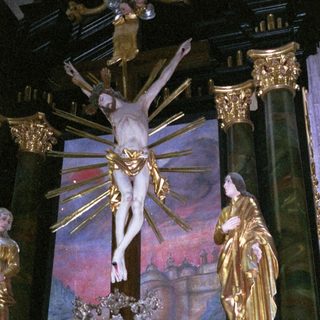Baroque altar depicting crucifixion with gilded statues.