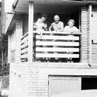Family posing together on a balcony.