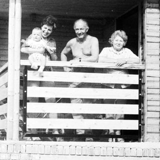 Family posing together on a balcony.