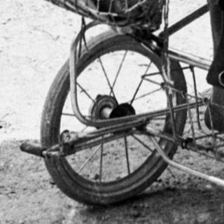 Baby in vintage stroller on forest path.