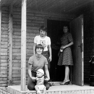 Family posing on porch with baby.