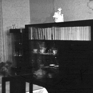 Vintage kitchen with shelf displaying figurine.