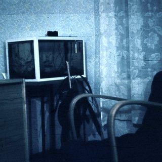 Vintage room with old TV and worn furniture.