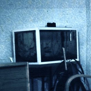 Vintage room with old TV and worn furniture.