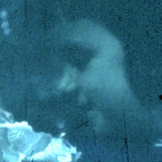 Blurred reflection of person holding folded towel.